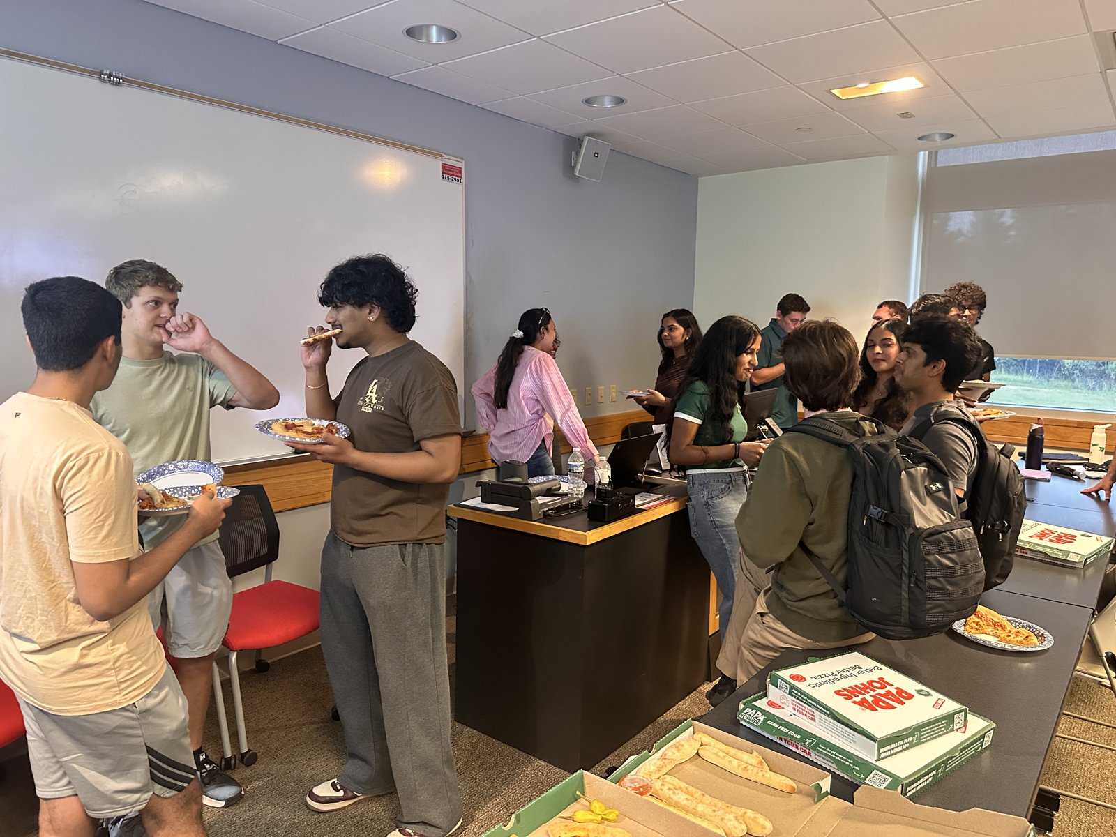 Students eating pizza and talking at the ACM interest meeting